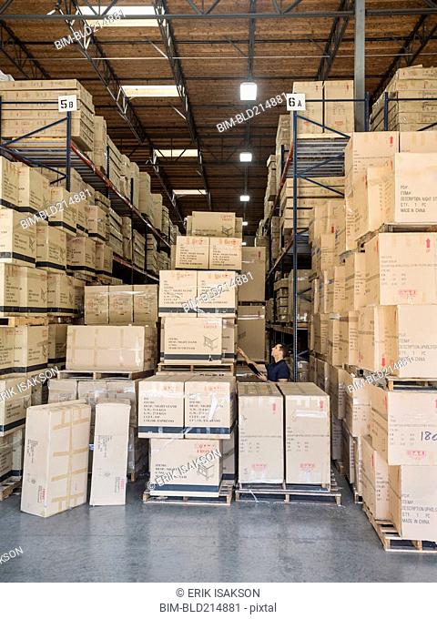 Caucasian worker examining cardboard boxes in warehouse