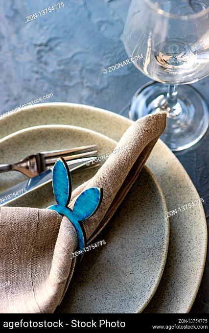 Table setting for festive Easter dinner on rustic background with copy space