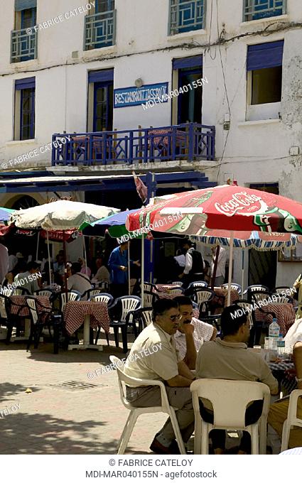 Men sitting outside a café in summer