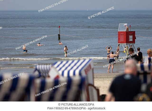02 June 2019, Lower Saxony, Norderney: A lifeguard watches over bathing children on the west beach. Photo: Janis Meyer/dpa