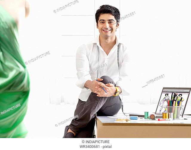 Smiling male clothing designer in workshop