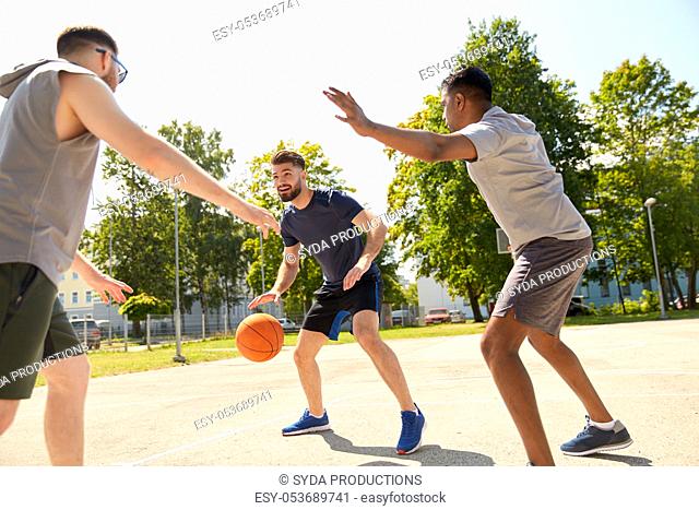 group of male friends playing street basketball