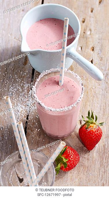 A creamy strawberry and coconut shake with a straw