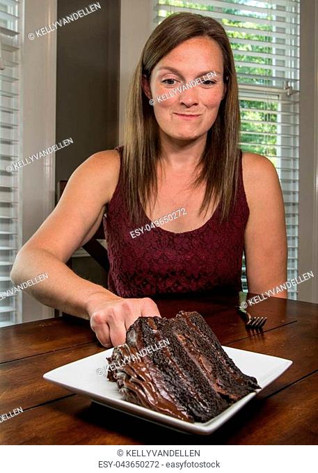 Woman Reaching for Slice of Chocolate Cake is excited to try a bite