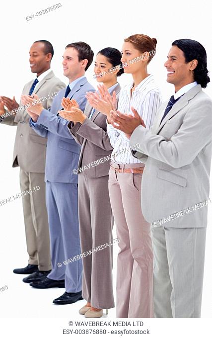 Business people smiling and applauding while looking towards the left side against white background