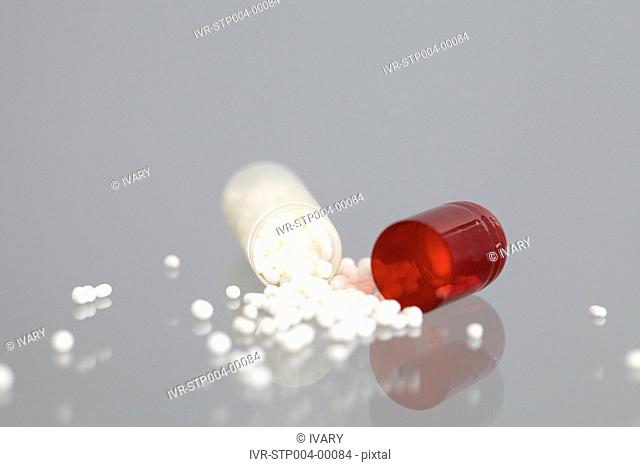 White tablets spilling out of white and pill bottles