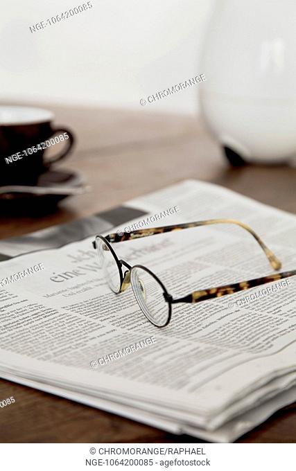 Newspaper at breakfast, coffee, glasses