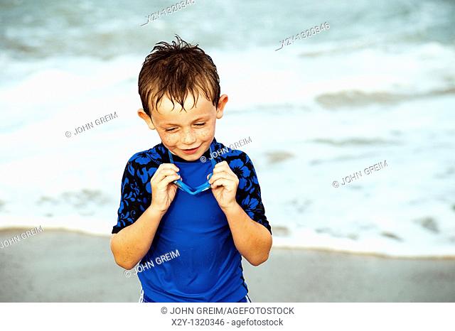 Young boy with goggles enjoys the ocean water