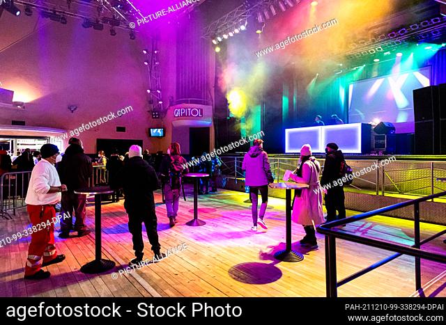 10 December 2021, Lower Saxony, Hanover: People stand at bar tables in front of the stage in the concert hall and wait for their vaccination