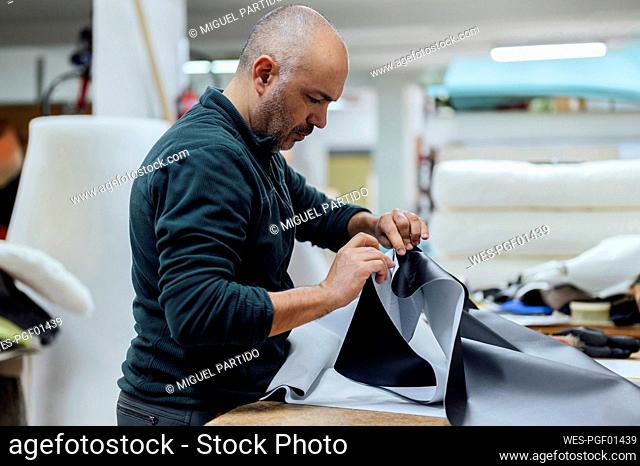 Craftsman working with fabric in workshop