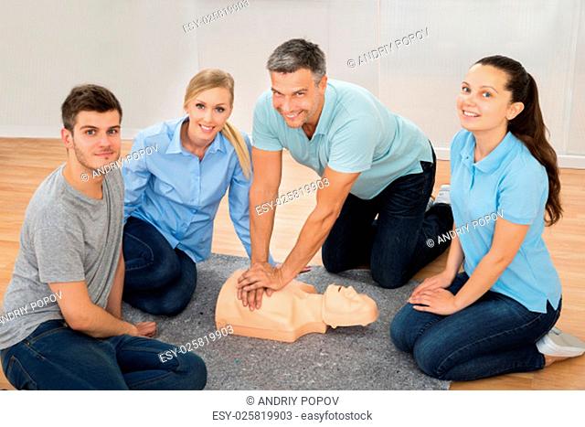 Mature Male Instructor Showing Cpr Training On Dummy To His Student