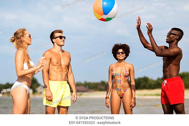 friends playing with beach ball in summer