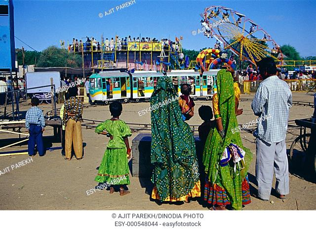 Family enjoying rides in Ravechi fair , Kutch , Gujarat , India
