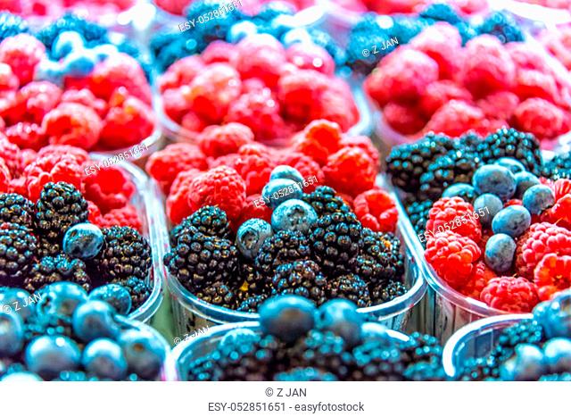 Raspberries, blueberries and blackbarries sold on the street market stall