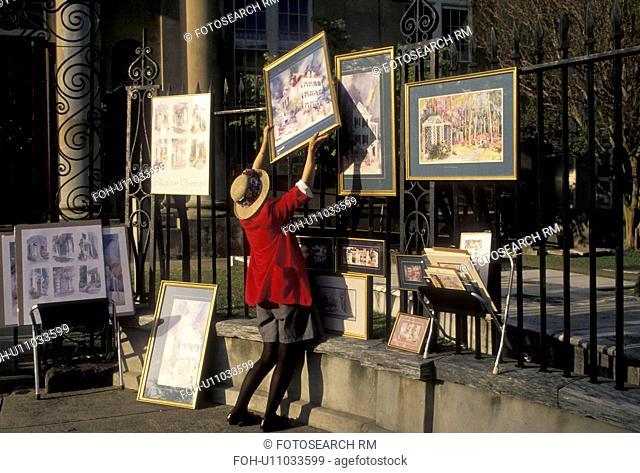 artist, Charleston, South Carolina, An artist hangs her paintings on a fence on Church Street for display in Charleston in the state of South Carolina