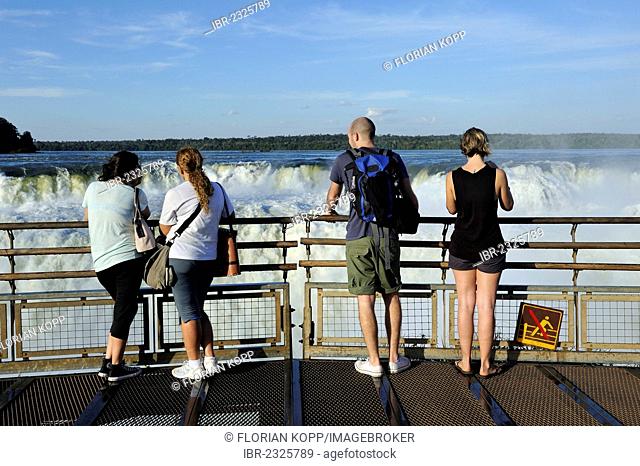 Tourists looking into the Devil's Throat, Garganta del Diablo, Iguazu or Iguacu Falls, UNESCO World Heritage Site, at the border of Brazil and Argentina