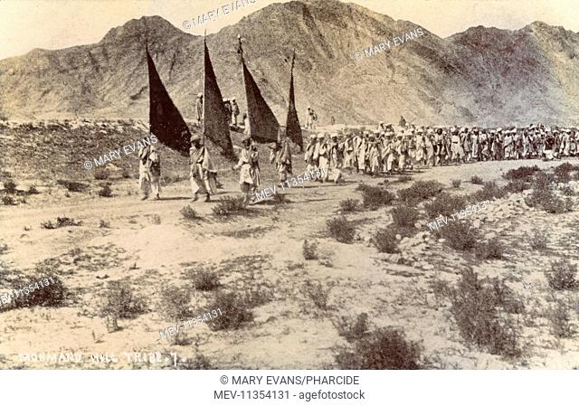 Mohmand Hill Tribe (a Pashtun tribe), marching with flags, North West Frontier Province, British India, near the border with Afghanistan