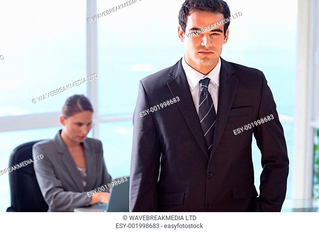 Young businessman with his secretary behind him