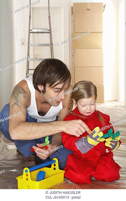 Girl 3-5 with father playing with plastic toolset
