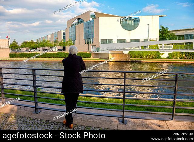 Senior blickt in Höhe des Spreeufer auf die Rückseite vom Bundeskanzleramt in Berlin