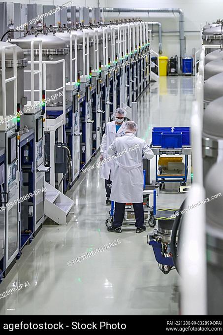 07 December 2022, Saxony, Freiberg: Two employees work in crystal growth at Freiberg-based Compound Materials GmbH. Gallium arsenide wafers for microelectronics...