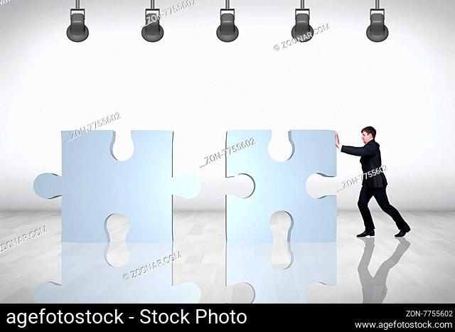 Businessman moving puzzle on the grey background