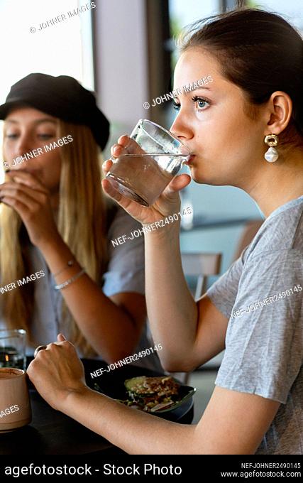 Woman drinking water in cafe