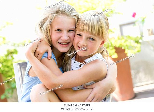 Portrait of two girls hugging outdoors