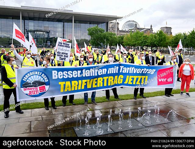 24 June 2021, Berlin: Employees of the driving service of the Bundestag demonstrate in front of the Reichstag building and the Paul-Löbe-Haus for a collective...