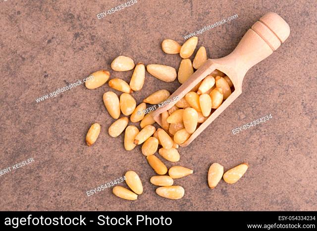 Pine nut seeds on a brown textured stone background, empty copy space