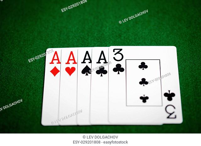 casino, gambling, games of chance, hazard and entertainment concept - poker hand of playing cards on green cloth