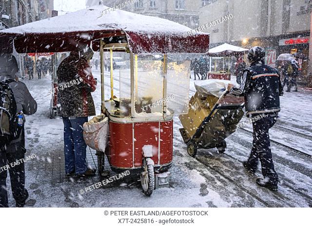 A hot chestnut stall during winter snow storm on Istiklal Caddesi, Beyoglu, Istanbul, Turkey,
