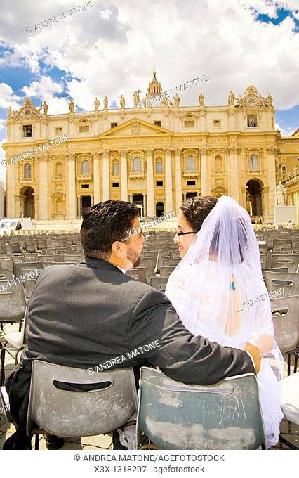 Portrait of bride and groom kissing n front of Saint Peter's square Vatican Rome Italy
