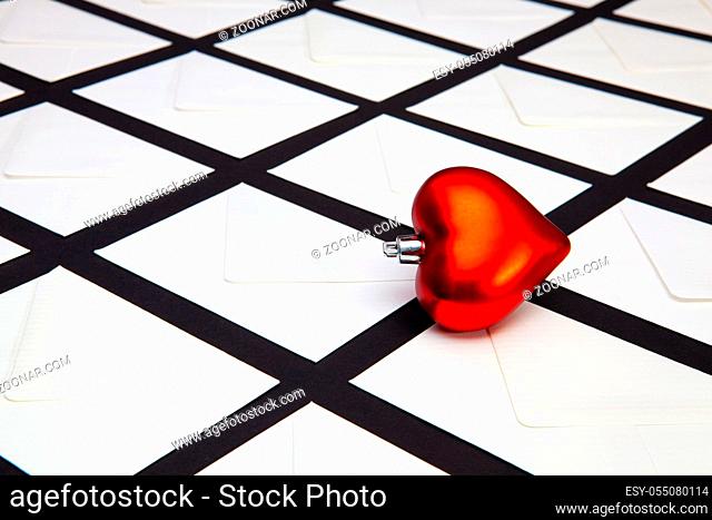Composition with white envelopes and red heart on the table. The photo suitable for various holidays and anniversaries