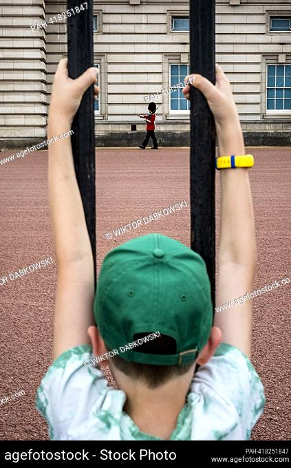 Child climbs fence to look at King’s Guards at Bauckingham Palace in London, United Kingdom on 20/07/2023 by Wiktor Dabkowski. - London/ENG/