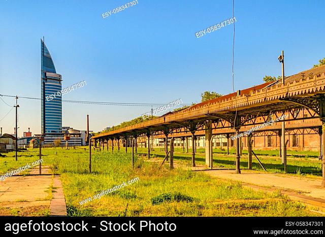 Abandoned old train station with contemporary tower building at background in aguada district, Montevideo, Uruguay