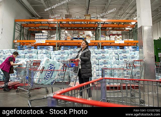 Shoppers take advantage of the supply of paper towels available at the Costco Wholesale store in Arlington, Va., Monday, March16, 2020