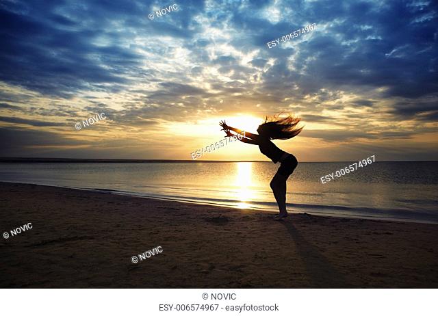 Dancing dynamic woman at the beach during sunset