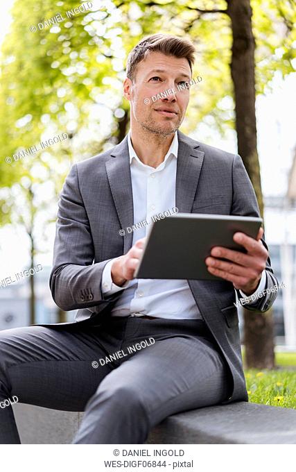 Businessman using tablet outside in the city