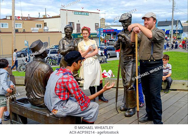 Actors in period dress pose beside namesake statues outside the Gulf of Georgia Cannery National Historic Site, Steveston, British Columbia, Canada