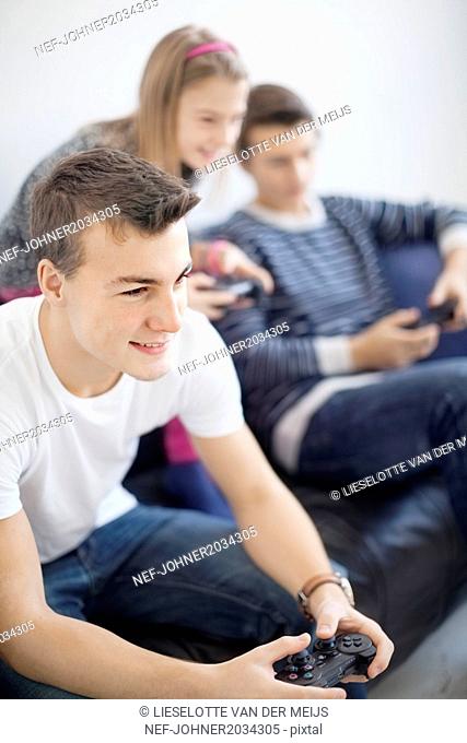 Children on sofa playing video game