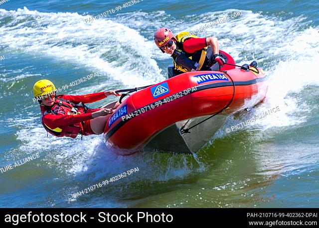 15 July 2021, Mecklenburg-Western Pomerania, Prerow: Lifeguards Jasmin Luciani (r) and Pauline Geipel from the DLRG water rescue team drive the lifeboat across...