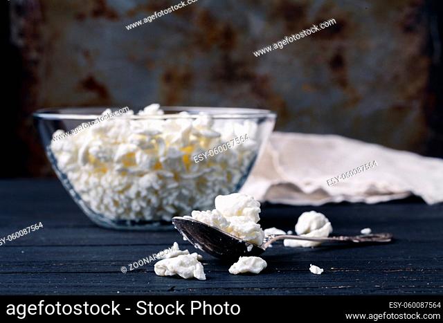 Fresh cottage cheese in dish on rustic table
