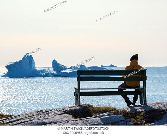 A seat with a view. The Inuit village Oqaatsut (once called Rodebay) located in the Disko Bay. America, North America, Greenland, Denmark