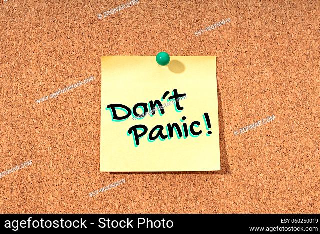 Dont panic message on yellow note on cork board