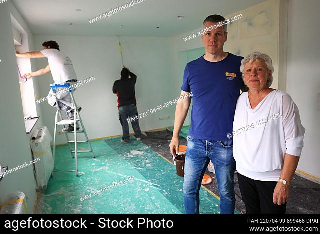 PRODUCTION - 10 June 2022, North Rhine-Westphalia, Erftstadt: Maria Dunkel stands next to son Thomas in the living room of her house