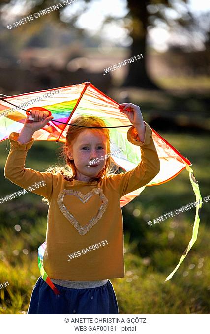 Portrait of redheaded girl holding a kite