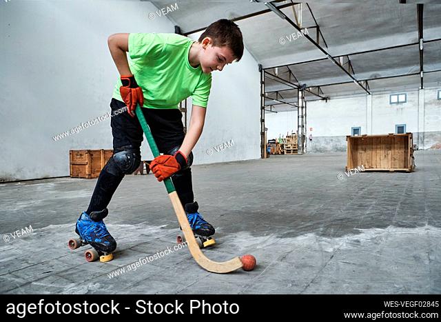 Boy practicing roller hockey during training at court
