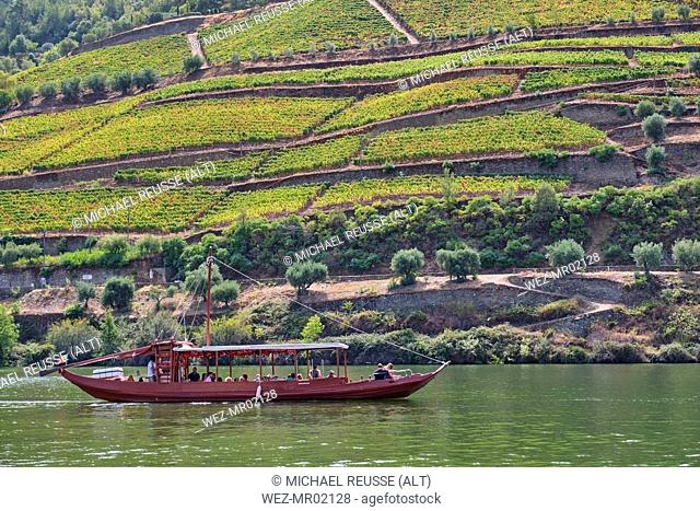 Portugal, Douro, Douro Valley, Tourboat on river in wine region seen over water