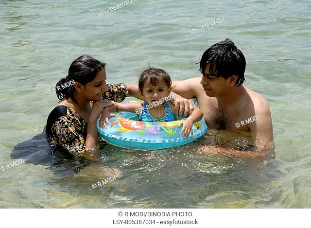 Parents and two year old baby girl enjoying swimming in Wadoor beach ; South Andaman Islands ; Bay of Bengal ; India MR 736J;736K;736L October 2008